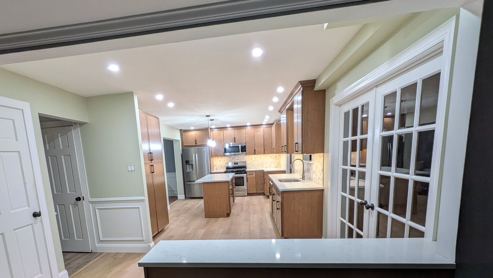 The same Horsham kitchen seen from the next room through a wide opening with a quartz counter