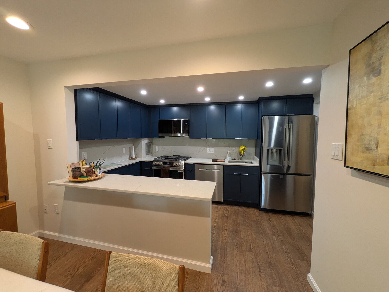 Navy kitchen with a white island and recessed lighting
