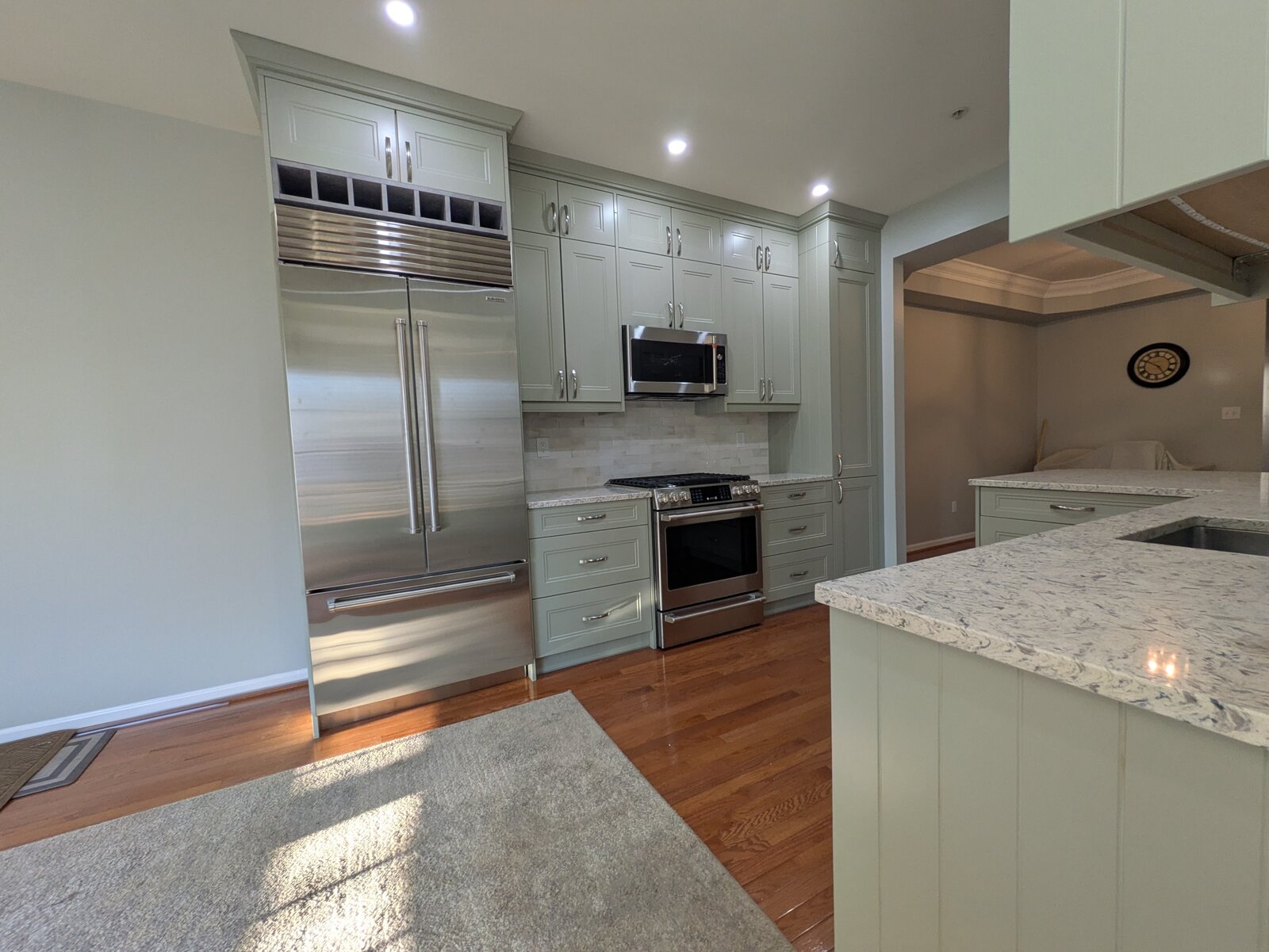 Sage kitchen with a pro-style refrigerator and inset cabinetry