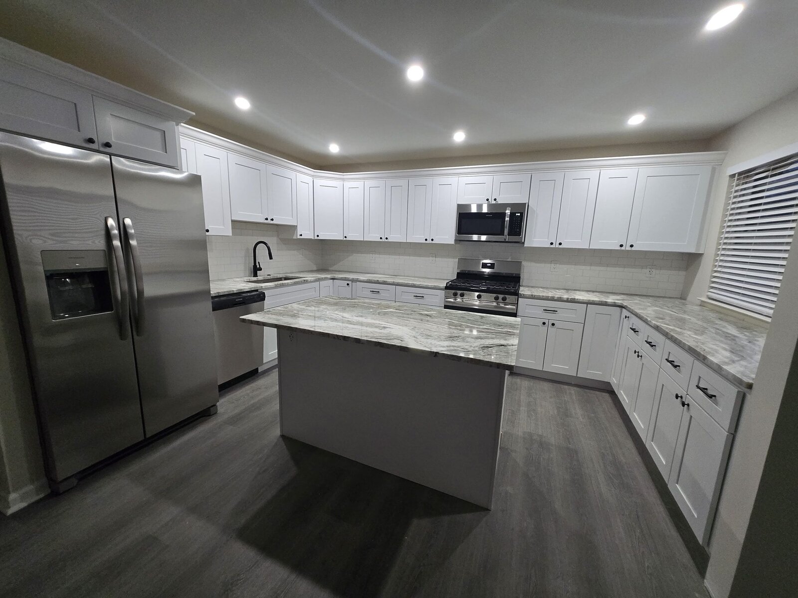 White kitchen with a gray island and a full wall of cabinetry