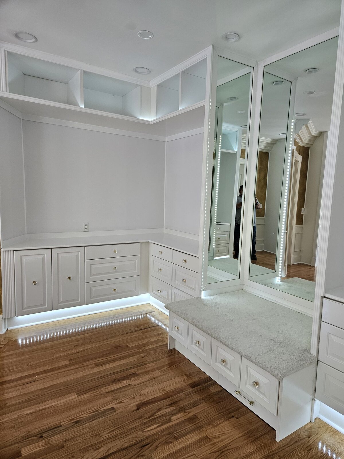 Custom built-in wall with window bench and mirrored cabinets